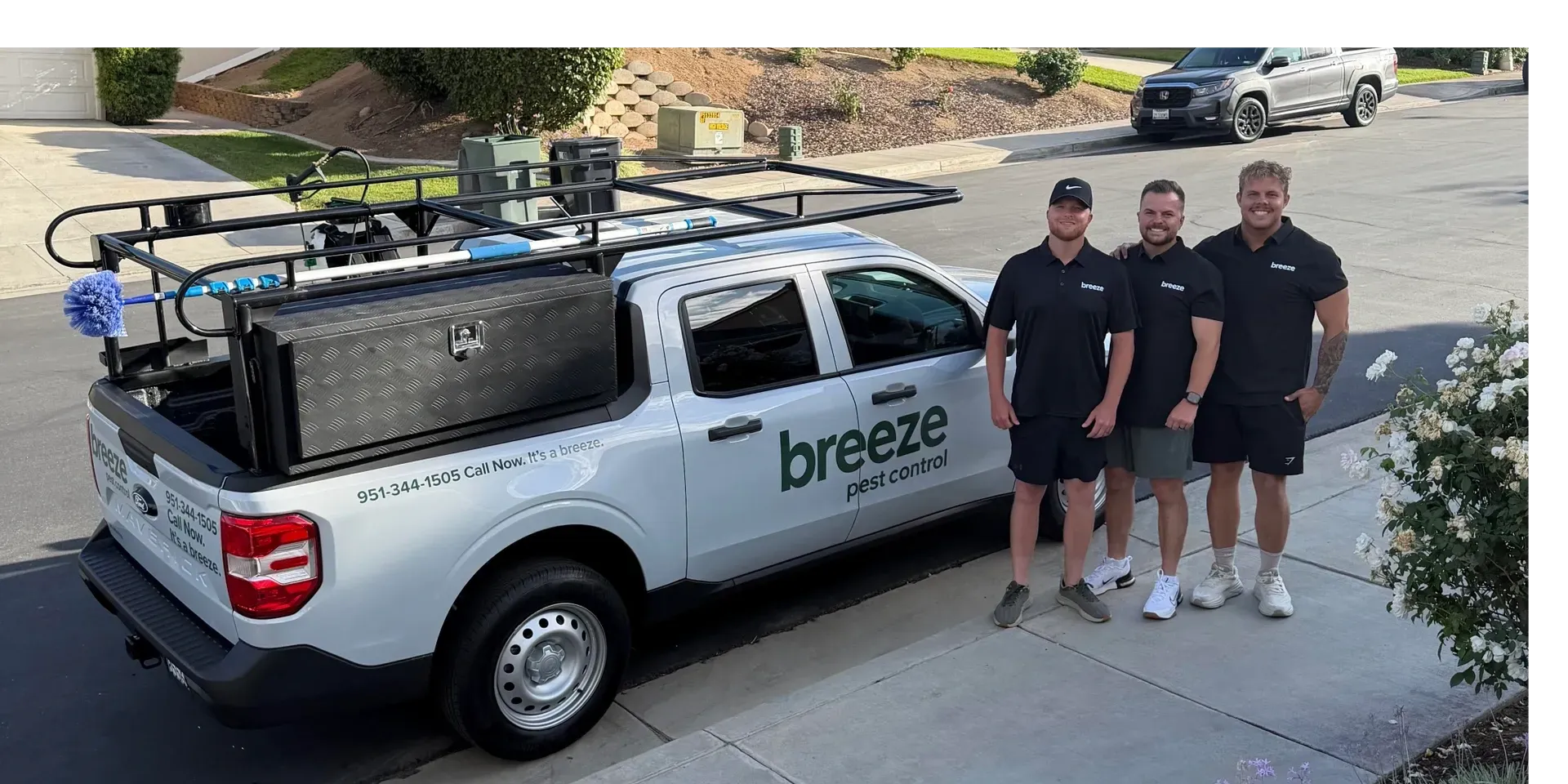 Breeze Pest Control service truck with three team members